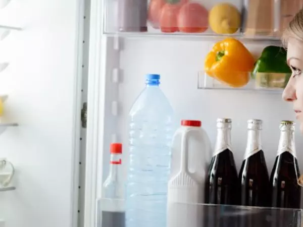 woman looking into refrigerator 