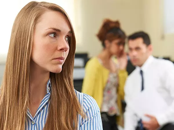 Woman trying to ignore man and woman whispering in background
