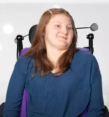 Teenage girl in wheelchair smiling.