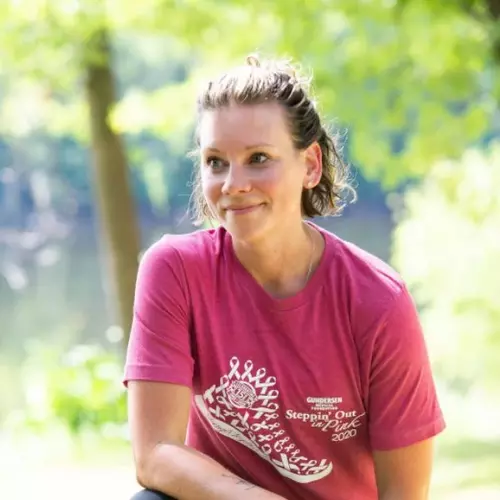 Breast cancer survivor dressed in pink t-shirt and smiling in the sunshine.