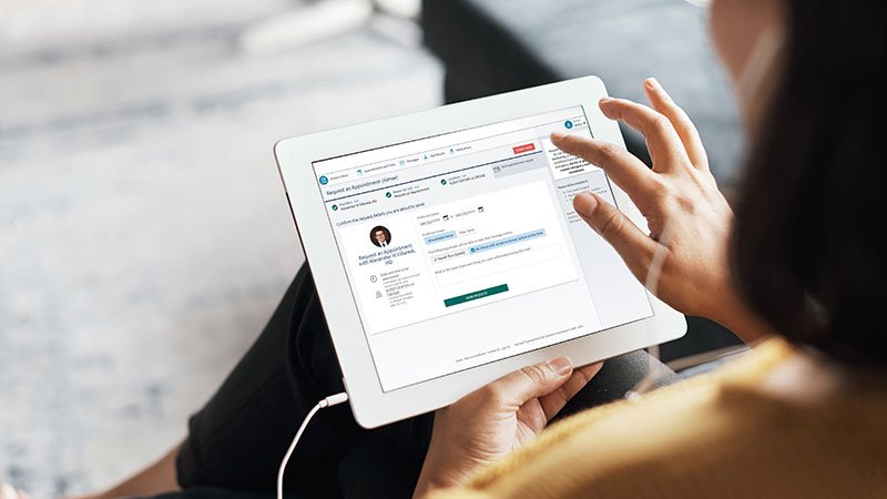 woman sitting on couch with tablet on MyCare