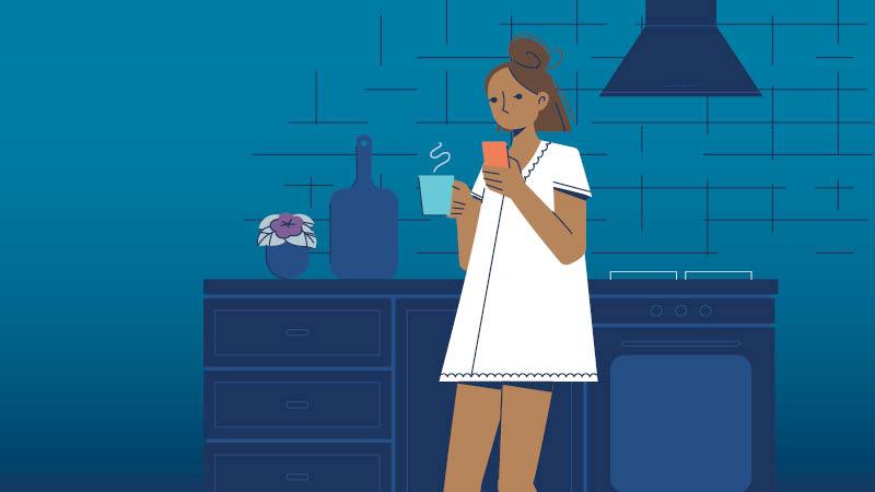 woman in kitchen looking at her phone