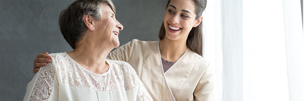 a certified nursing assistant smiling with patient