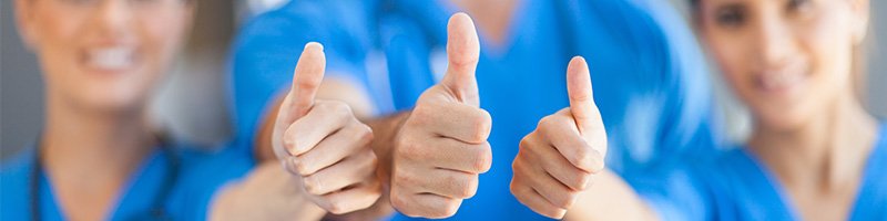 close up of 3 nurses giving a thumbs up to the camera