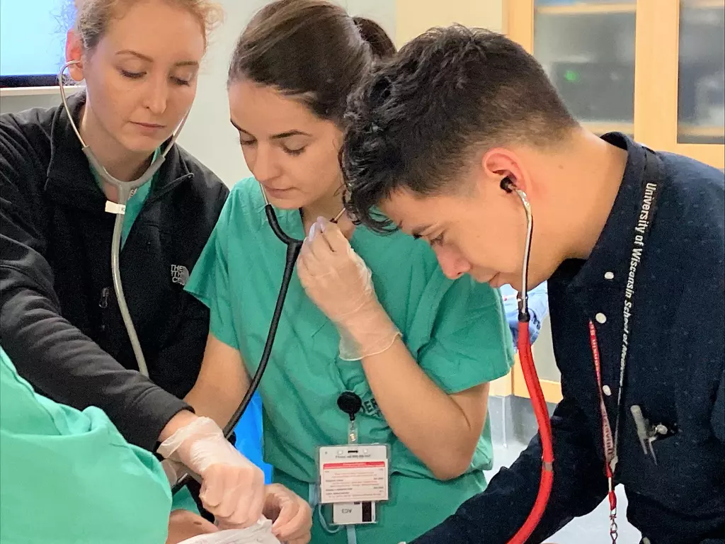 Medical students practicing with stethoscope.