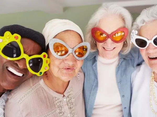 4 elderly women with funny sunglasses on smiling