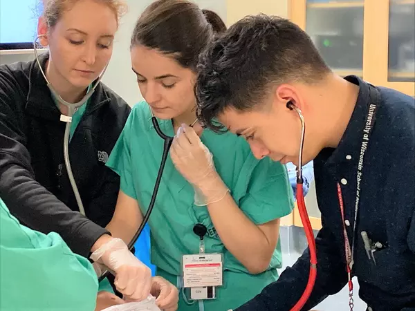 Medical students practicing with stethoscope.