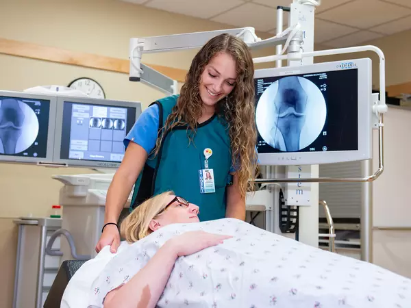 Physician assistant student helping patient through imaging procedure.