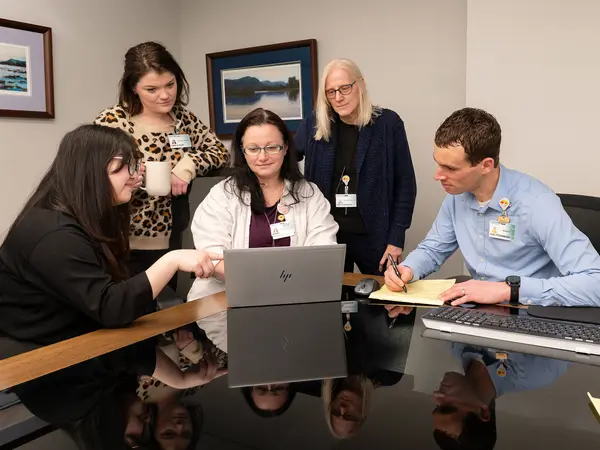 Five research navigation professionals collaborating in conference room.