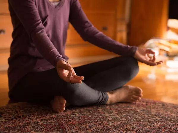 Woman sitting with legs crossed in meditation pose.