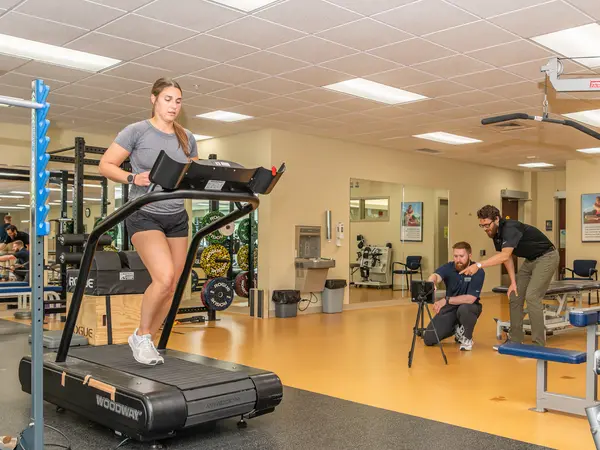 Woman running on treadmill in Onalaska Sports Physical Therapy Gym.
