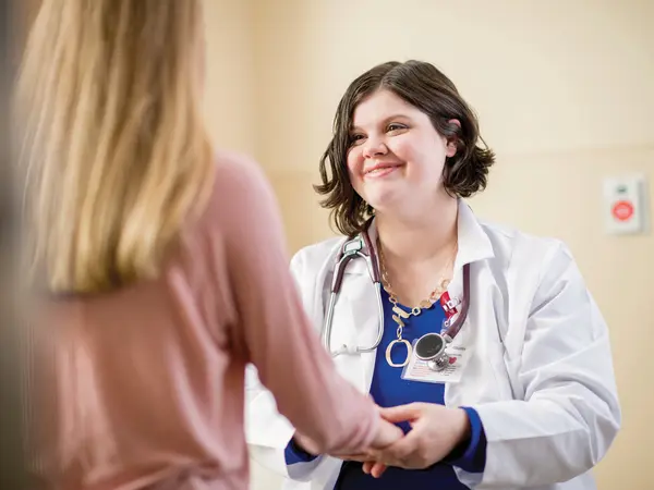 Adult female doctor examining a young teenage girl patient.