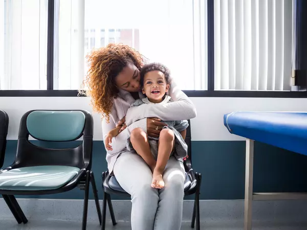 Woman with baby girl sitting in pediatrician waiting room