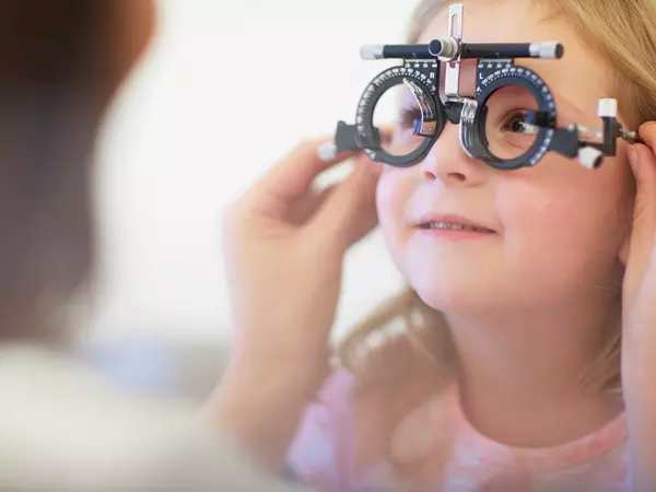 Eye doctor examining young girl's vision