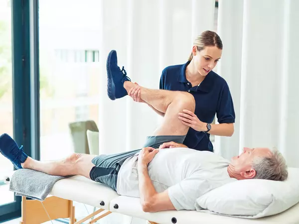 Physiotherapy doctor helps senior patient