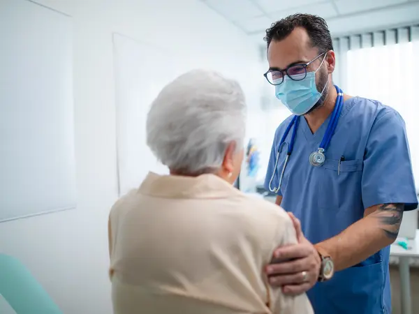 Doctor with elderly patient in examination room
