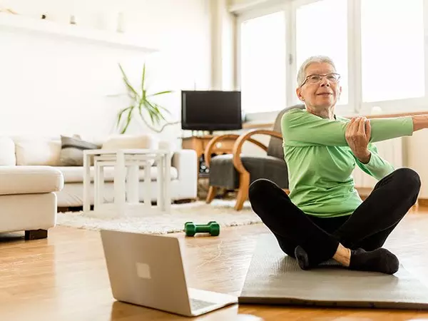 older woman exercising virtually