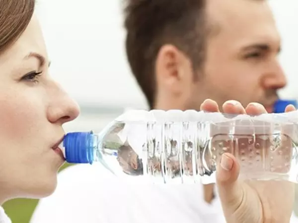 Man and woman drinking bottled water
