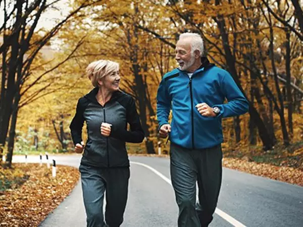 a couple jogging on a road in the fall