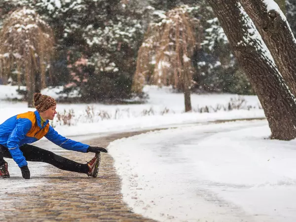 woman stretching on walkway during winter