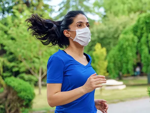woman running outside with a mask