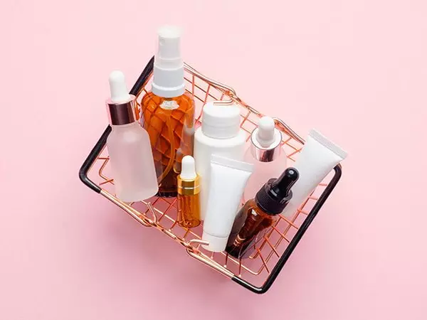 basket of skincare products on a pink background