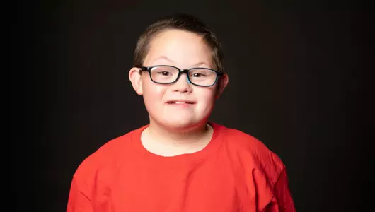 young man smiling in red shirt