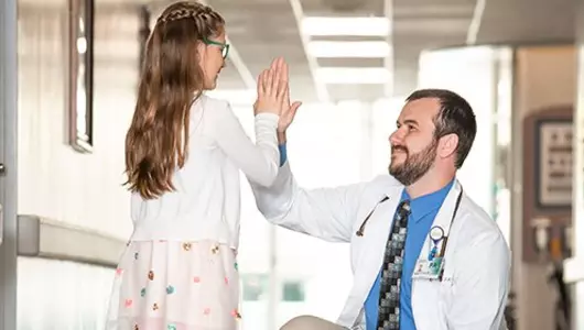 Dr giving hi5 to girl