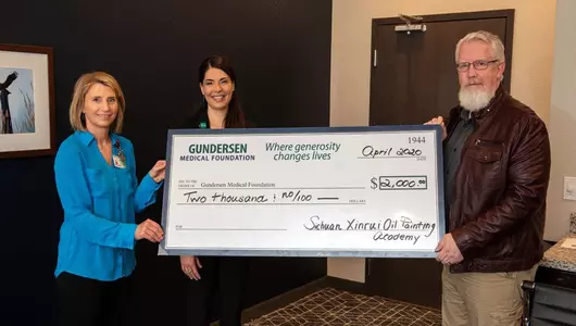 Pictured (left to right) are Kim Hanson, Purchasing; Mandy Nogle, director of Development, Gundersen Medical Foundation; and Marc Barger, representing Sichuan Xinrui Oil Painting Academy.