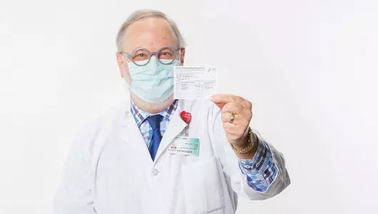 Dr. Rathgaber holding his vaccine card