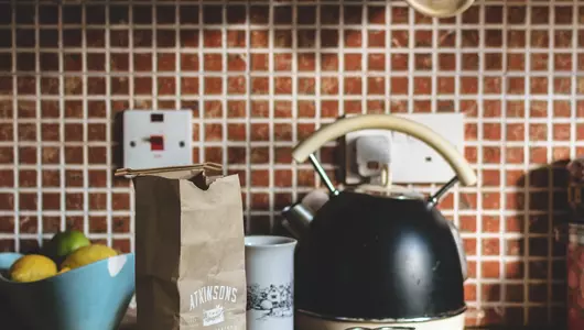 Tea kettle resting on kitchen countertop.