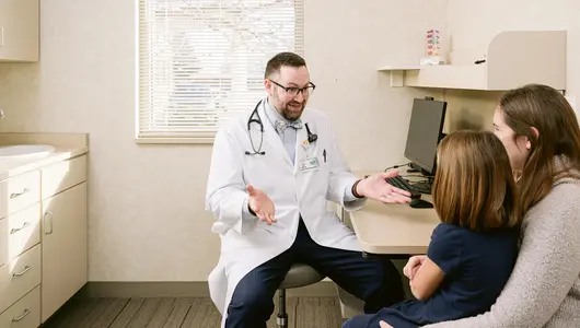 male-nurse-speaking-with-mother-and-daughter