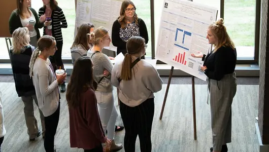 Group of women listening to research presenter.