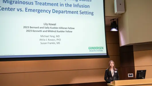 Summer research fellow presenting at podium.