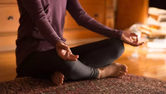 Woman sitting with legs crossed in meditation pose.