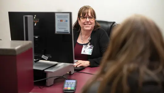 Gundersen Moundview Hospital receptionist helping patient at desk.