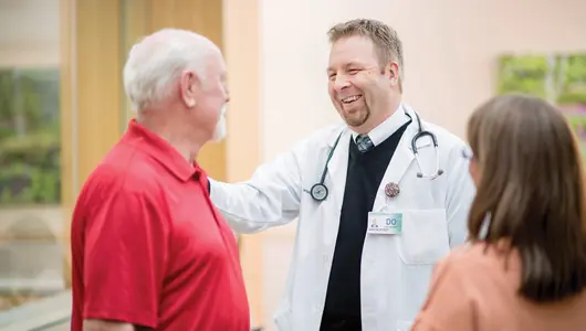 physician-smiling-at-patient-with-hand-on-patients-shoulder