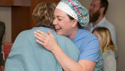 nurse-excellence-winner-hugs-coworker-with-big-smile