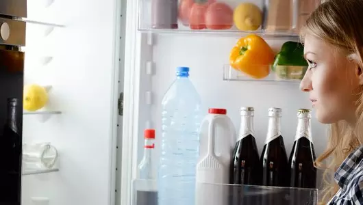 woman looking into refrigerator 