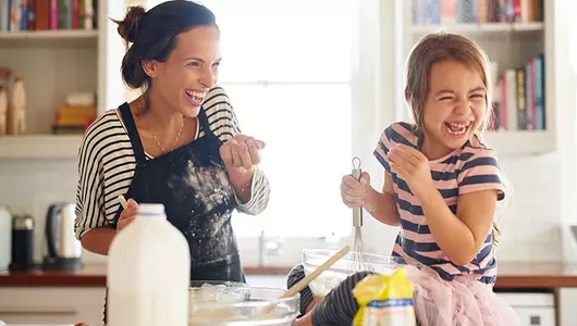 Mom and child having fun baking in kitchen
