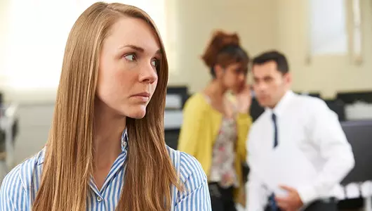 Woman trying to ignore man and woman whispering in background