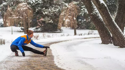 woman stretching on walkway during winter