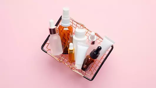basket of skincare products on a pink background