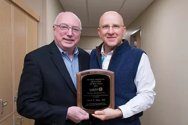 Paul Klas, MD, Family Medicine Educator of the Year (right), is presented with a plaque by Wisconsin Academy of Family Physicians executive director, Larry Pheifer