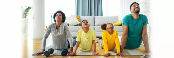 family of four stretching on yoga mats