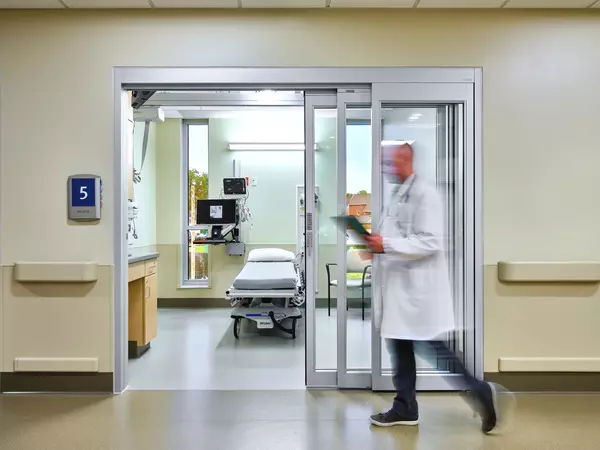Doctor walking in specialty clinic hallway.