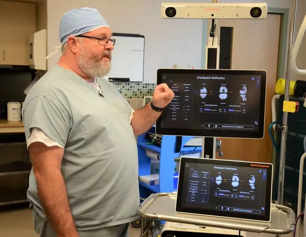 Doctor with equipment for robotic surgery in hospital room.