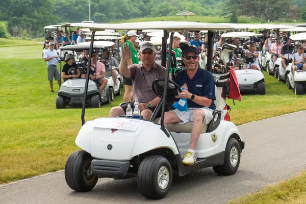 Two golfers getting riding in golf cart