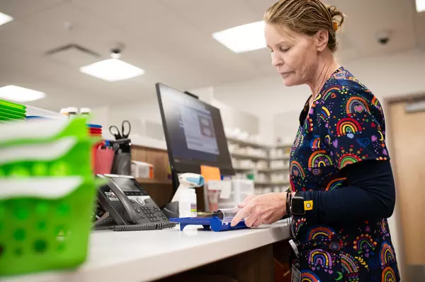 Pharmacy staff member helps fill a prescription.