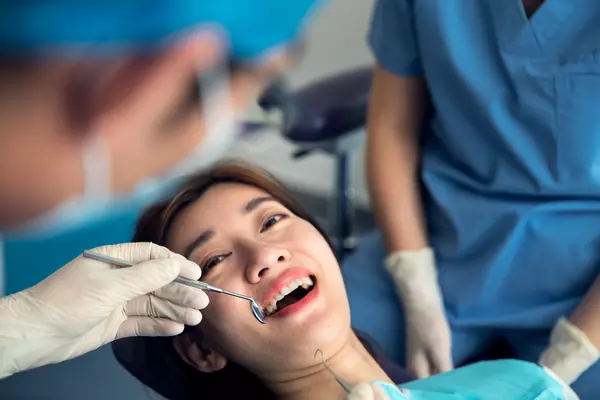 The dentist treats the young women's teeth in the dental clinic